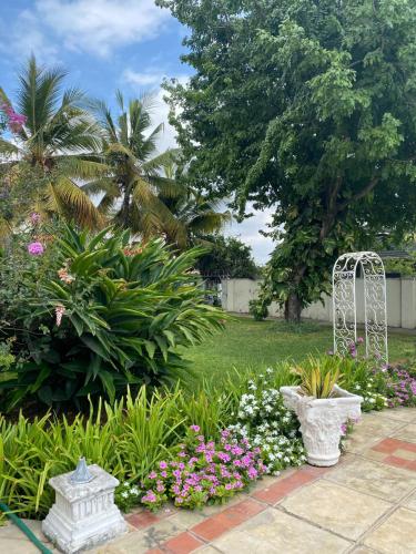 a garden with pink and white flowers in a yard at Zing gardens E06 in Mombasa