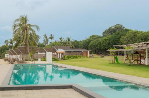 a swimming pool in a resort with a playground at Sadi Beach House in Telukbakau