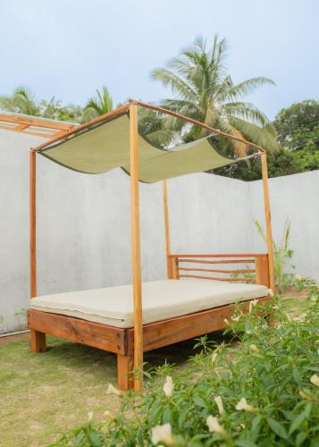 a bed with a canopy in a yard at Sadi Beach House in Telukbakau