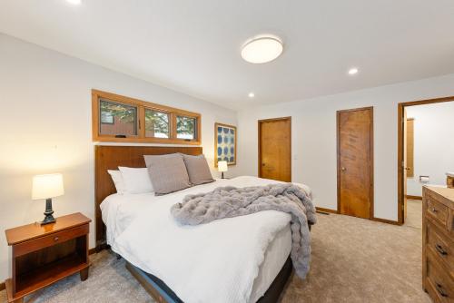 a bedroom with a large bed and a dresser at Cabin for 8 HotTub Close to Ski Town Private Beach in Tahoe City