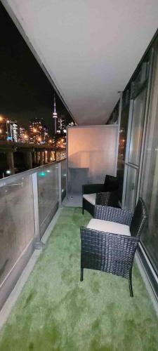 a balcony with a table and chairs on a building at Luxury Downtown Condo with CN tower views, Pool Access, Gym,Free Parking upon request at booking, accommodates 4 in Toronto