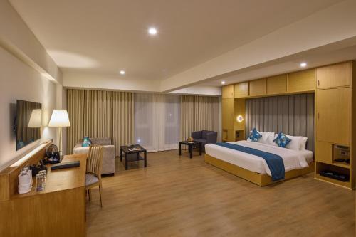 a hotel room with a bed and a desk at Grand Continent Mahabalipuram A Sarovar Premiere Affiliate Hotel in Mahabalipuram