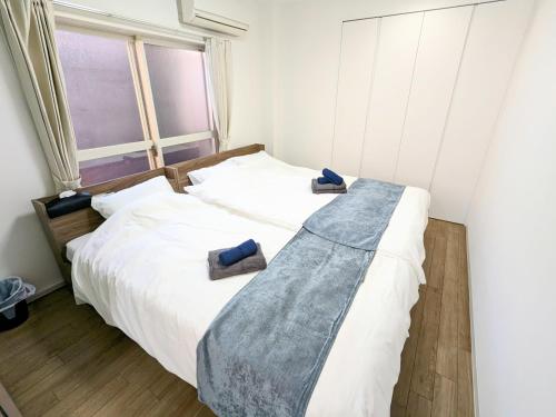 a bedroom with a large white bed with two pillows on it at SEIRYU Bldg in Tokyo