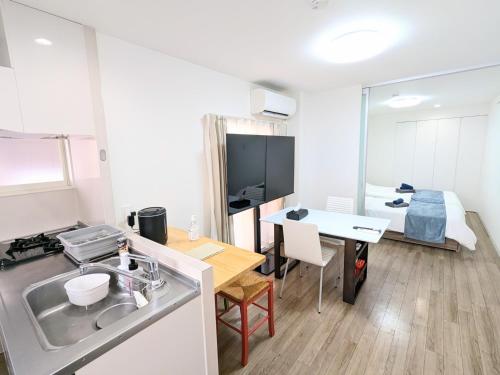 a kitchen with a sink and a table in a room at SEIRYU Bldg in Tokyo