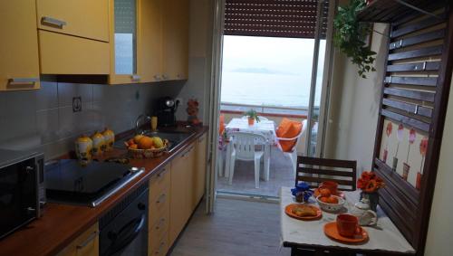 a kitchen with a sink and a table with a view of the ocean at Terrazza Sul Mare in Terme Vigliatore