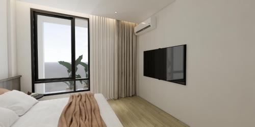 a bedroom with a large window and a tv at The Explorer Hotel in Melaka