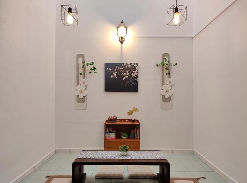 a room with a table and flowers on the wall at SS Ipoh Comfort Homestay - Taman Bertuah in Ipoh