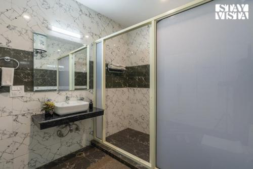 ein Badezimmer mit Waschbecken und Dusche in der Unterkunft StayVista at Pinecrest Manor - Outdoor Jacuzzi in Kasauli