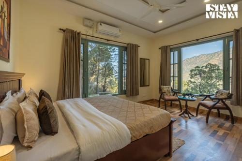 ein Schlafzimmer mit einem Bett und einem großen Fenster in der Unterkunft StayVista at Pinecrest Manor - Outdoor Jacuzzi in Kasauli