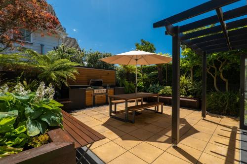a patio with a table and an umbrella at Luxurious Central City Living in Christchurch