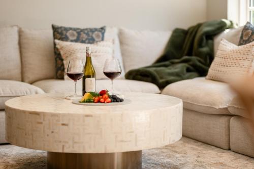 a table with two glasses of wine and a plate of fruit at Luxurious Central City Living in Christchurch
