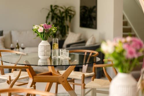 a glass table with flowers in a living room at Luxurious Central City Living in Christchurch