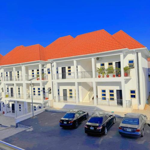 two cars parked in a parking lot in front of a building at Comfortable 1 bedroom Apartment in Garki