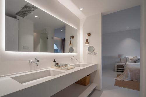 a white bathroom with a sink and a mirror at Miyue Shenzhen Blue and White Holy Island Cliff Pool Hotel in Shenzhen