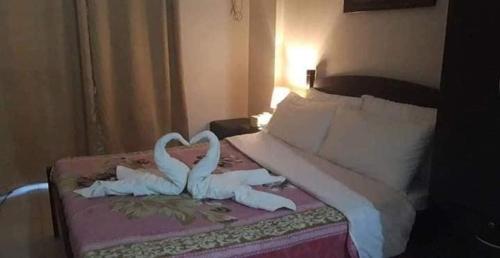two white swans making a heart on a bed at The Redwoods SM Fairview with Balcony in Manila