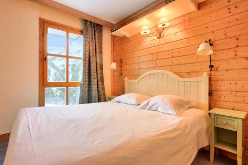 une chambre avec un lit blanc et une fenêtre dans l'établissement Résidence Les Arcs 1950 Le Village - maeva Home - Appartement 3 pièces 6 personnes - Prestige MAE-5091, à Bourg-Saint-Maurice