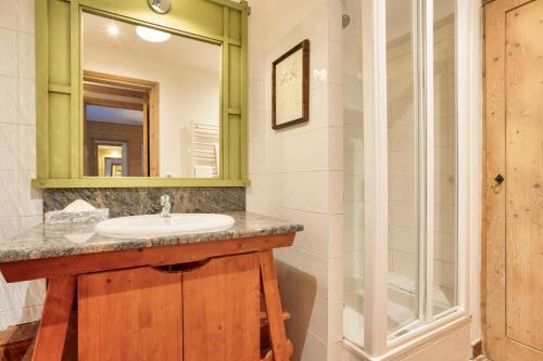 une salle de bain avec un lavabo et un miroir dans l'établissement Résidence Les Arcs 1950 Le Village - maeva Home - Appartement 3 pièces 6 personnes - Prestige MAE-5091, à Bourg-Saint-Maurice