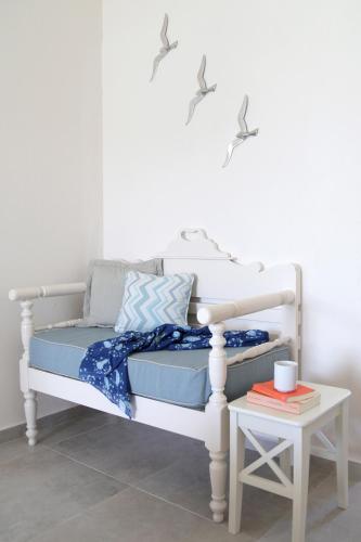 a white bed with blue sheets and a side table at Skopelos Village Hotel in Skopelos Town