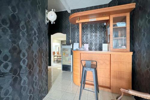 a restaurant with a bar with a stool in front of it at RedDoorz Syariah at Aziziah Homestay Lampung in Kedaton