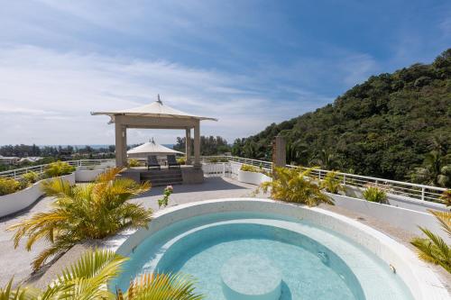 a swimming pool in a yard with a gazebo at Phunawa Resort Phuket Karon Beach - SHA Plus in Karon Beach