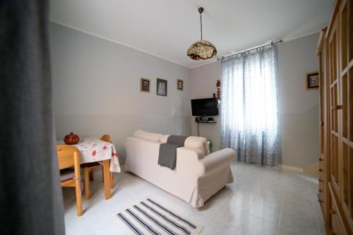 a living room with a white couch and a table at Casette Bianche in Casalbordino