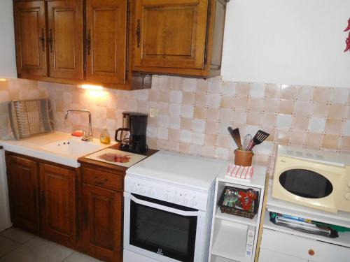 a kitchen with a white stove top oven next to a microwave at Gîte indépendant, 2 ch, proche A5, jardin clos, garage - FR-1-611-111 in Richebourg