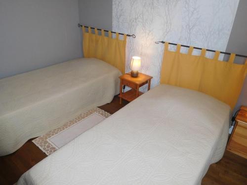 two beds in a room with a lamp on a table at Gîte indépendant, 2 ch, proche A5, jardin clos, garage - FR-1-611-111 in Richebourg