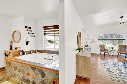 ein Badezimmer mit Badewanne und ein Wohnzimmer in der Unterkunft Villa near Yosemite & bass lake w/Hot Tub/EVcharge in Oakhurst