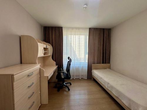 a bedroom with a bed and a desk and a window at Comfortable 3 bedroom apartment in Ulaanbaatar in Ulaanbaatar