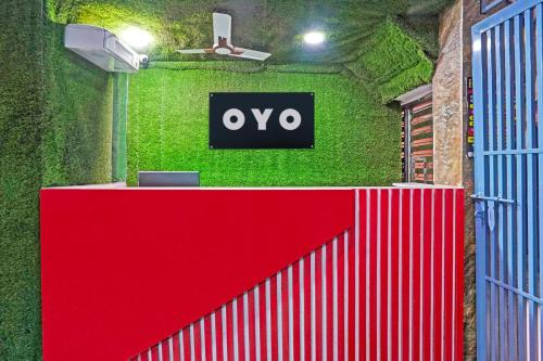 a red gate with an ovy sign on a green wall at Hotel O The Arrow in New Delhi