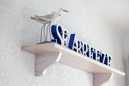 a bird sitting on top of a sign on a shelf at Skopelos Village Hotel in Skopelos Town