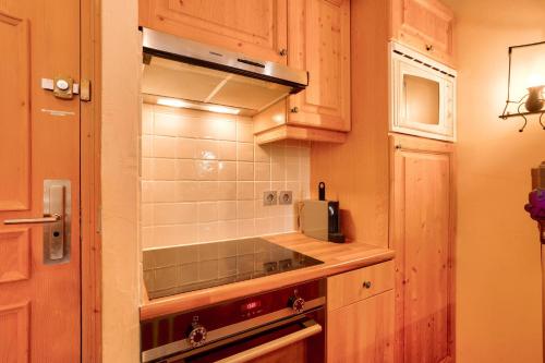 une cuisine avec une cuisinière et un micro-ondes dans l'établissement Résidence Les Arcs 1950 Le Village - maeva Home - Appartement 3 pièces 6 personnes - Prestige - super Home MAE-2721, à Arc 1950