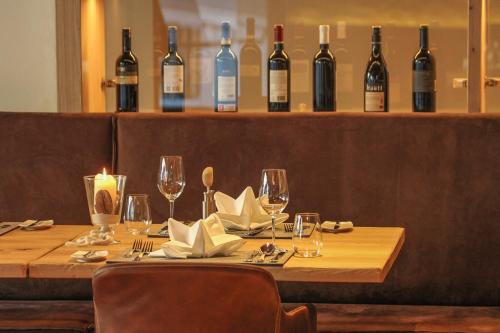 a wooden table with wine glasses and bottles of wine at Hotel Edelweiss in Saalbach Hinterglemm