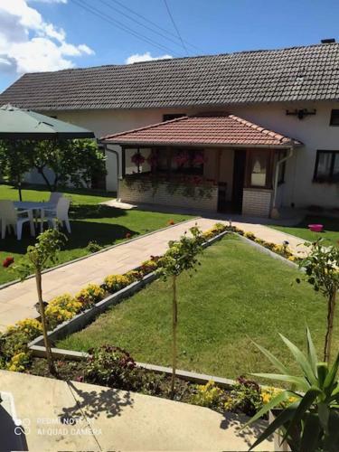 a house with a garden in front of a house at Etno kutak Jaćimović in Gornji Milanovac