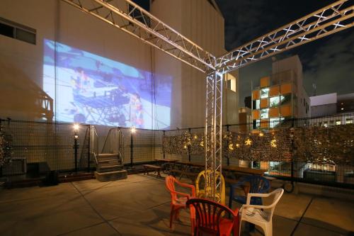 a room with chairs and a large screen on a building at HOTEL TRAD Replay in Osaka