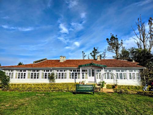 a large white building with a red roof at Milhaven Crest in Kodaikānāl