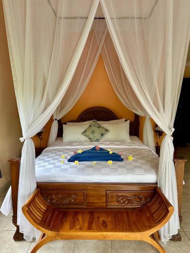 a bedroom with a bed with a canopy at Bali Bhuana Beach Cottages in Amed