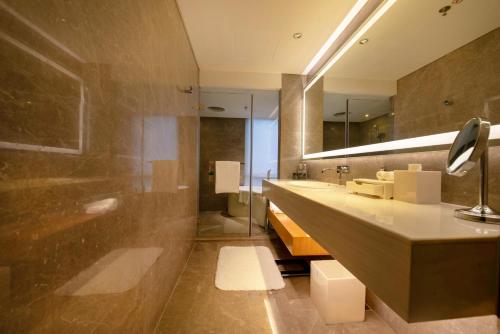 a bathroom with two sinks and a large mirror at Renaissance Beijing Wangfujing Hotel in Beijing