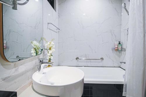 a white bathroom with a sink and a bath tub at RESidenza Condonium - D1mension & Zenity Tower, SG's Heart & Gym, Pool in Ho Chi Minh City