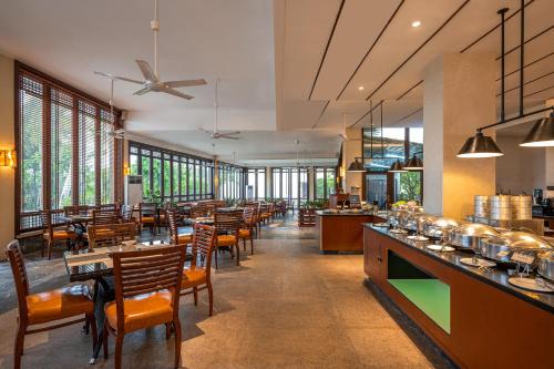 a dining room with tables and chairs and windows at Tianhong Resort Hotel, Yalong Bay, Sanya in Sanya