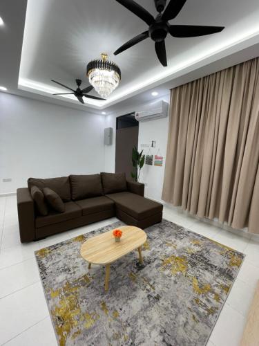 a living room with a couch and a coffee table at Azzahra Homestay Scientex Kundang Jaya Rawang in Pengkalan Kundang