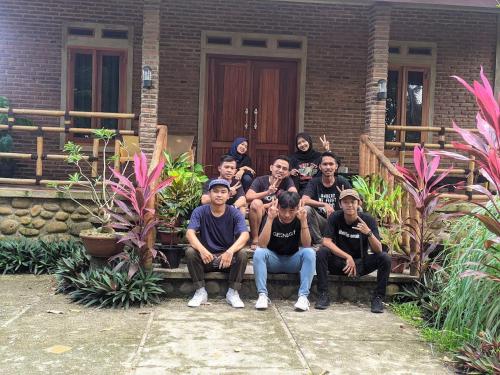 a group of men sitting on a bench in front of a house at Giazvillacarita in Sukarame