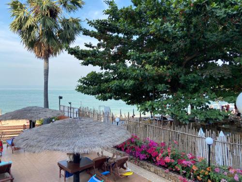 a group of people sitting under an umbrella on the beach at Amazing Spacious Seaview Condo in North Pattaya