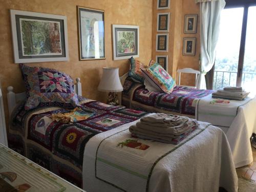 une chambre avec deux lits et une fenêtre dans l'établissement Villa la Cerisaie., à Céret