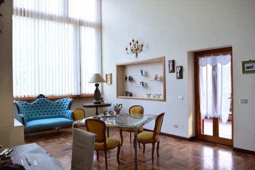 a living room with a glass table and chairs at Villa dei Gelsomini, Residenza nel verde in Viterbo