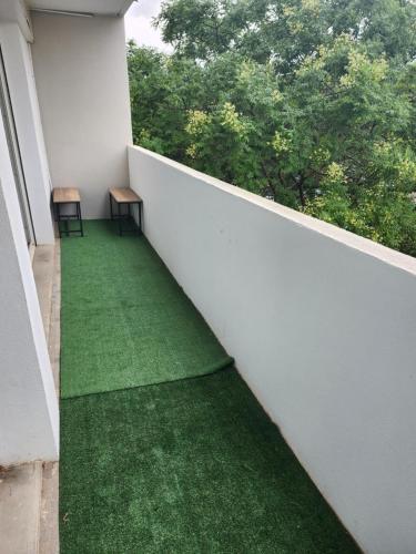 - un balcon avec un sol vert et 2 chaises dans l'établissement Joli F3 Montpellier proche mer et centre ville, à Montpellier
