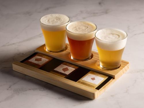 three glasses of beer on a wooden tray at Tokyo Bay Shiomi Prince Hotel in Tokyo