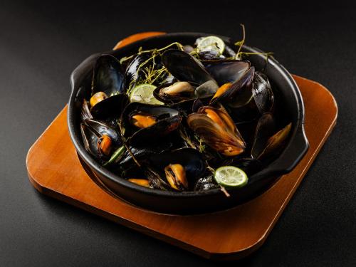 a black bowl of mussels on a plate at Tokyo Bay Shiomi Prince Hotel in Tokyo