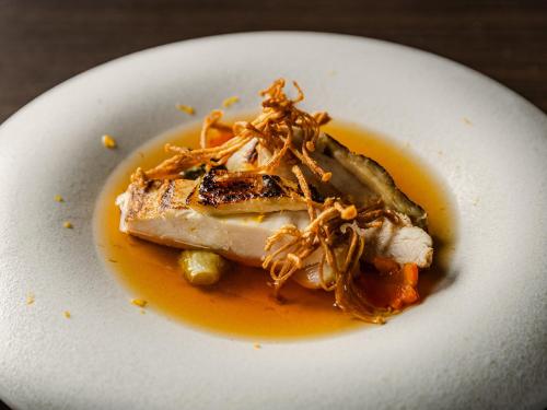 a white plate with a piece of food with orange sauce at Tokyo Bay Shiomi Prince Hotel in Tokyo