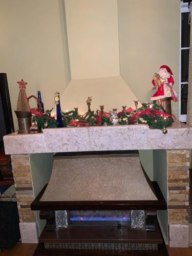 a fireplace with christmas decorations on top of it at Vikendica na dan na Fruskoj gori in Vizić